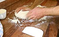 Verarbeitung von Brotteig fr Salzstangerl auf einer Massivholz-Arbeitsflche
