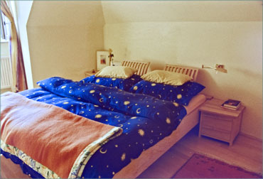 Doppelbett leicht schrggestellt, mit Wandanschluflche als Aablage und Nachtkstchen.